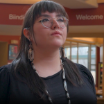 student looks ahead with black shirt, inside Indigenous student centre building